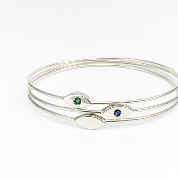 Combinació de dues polseres de plata amb disseny geomètric estilitzat amb maragda verda i safir blau engastats.