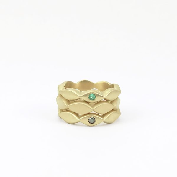 Bagues en or 18 carats sculptées à la main au design géométrique, avec émeraude et diamant noir, conçues pour s’emboîter entre elles comme bagues superposables.