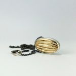 Pendentif ovale en argent avec détail doré en relief courbe