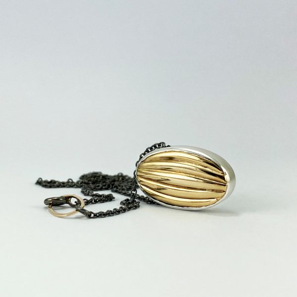 Penjoll ovalat de plata amb detall daurat en relleu corbat