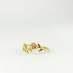 Anell d’or delicat i artesanal amb encant vintage, motiu floral i turmalina rosa encastada al centre