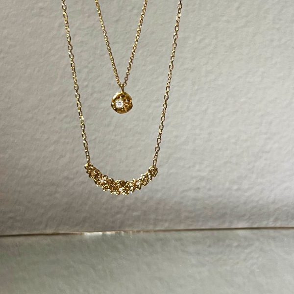 Colliers en or recyclé faits sur mesure ; l’un avec pendentif rond lisse, l’autre avec grappes de perles brillantes, tous deux sertis de diamants blancs et chaîne fine.