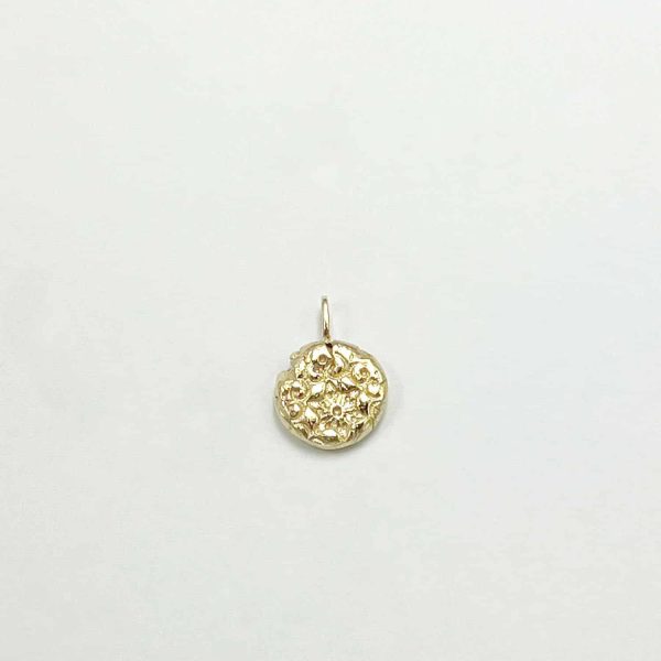 Pendentif artisanal rond en or avec gravure florale ancienne, sur fond blanc neutre
