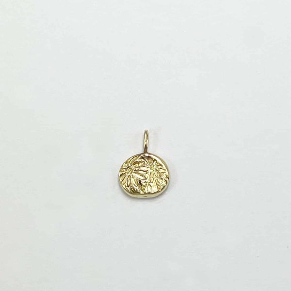 Pendentif artisanal rond en or avec gravure florale style ancien, sur fond blanc neutre