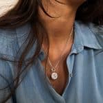 Collaret artesanal de plata amb penjoll d'estampat antic i quatre safirs blaus, sobre camisa blava