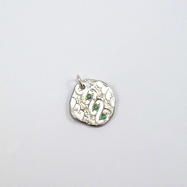 Pendentif rond en argent avec gravure ondulée ancienne et trois émeraudes vertes, sur fond blanc