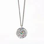 Collaret de plata oxidada amb medalla rodona inspirada en pedra erosionada amb pedres precioses maragda citrí i turmalina rosa.