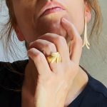 Arracades de plata xapada en or amb forma allargada d’inspiració vegetal.