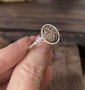 Anillo de plata de joyería artesanal con detalle antiguo engastado y dos zafiros rosas a cada lado.